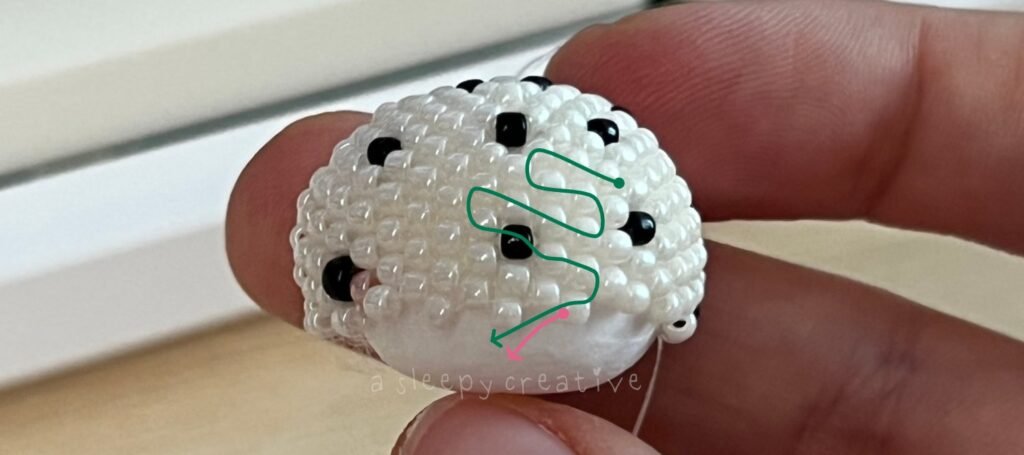 Green line showing the zig-zag path to weave a new thread through the beads of a white 3D beaded piece, changing direction several times